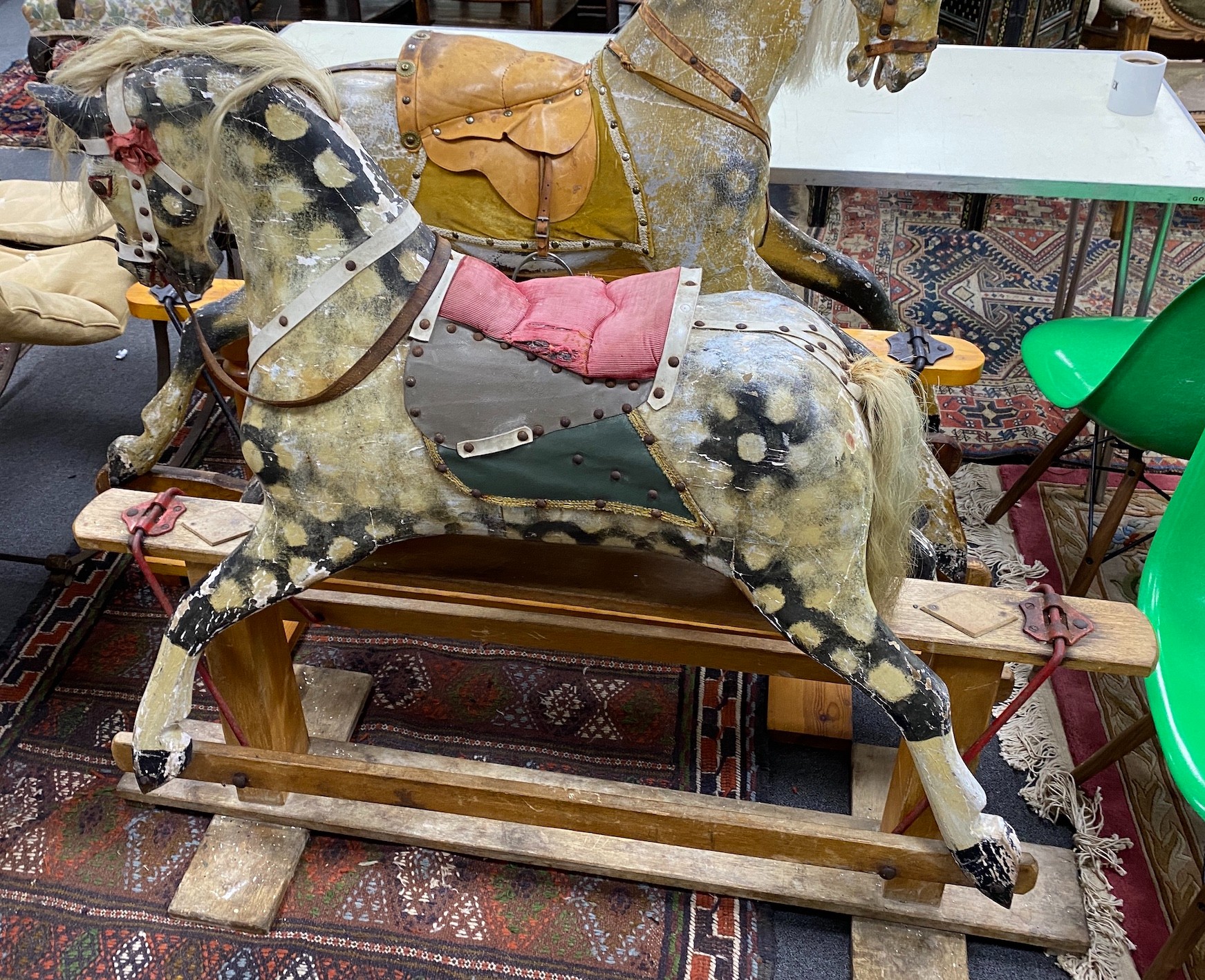 An early 20th century Ayres type carved wood and dappled rocking horse on safety frame, length 138cm, height 116cm